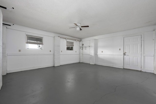 garage with a wainscoted wall and a ceiling fan