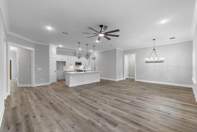1720 25th St, Niceville, FL 32578 - unfurnished living room with ceiling fan, baseboards, crown molding, light wood-style flooring, and a chandelier