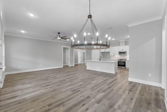 1720 25th St, Niceville, FL 32578 - unfurnished living room with ornamental molding, a ceiling fan, baseboards, light wood finished floors, and recessed lighting