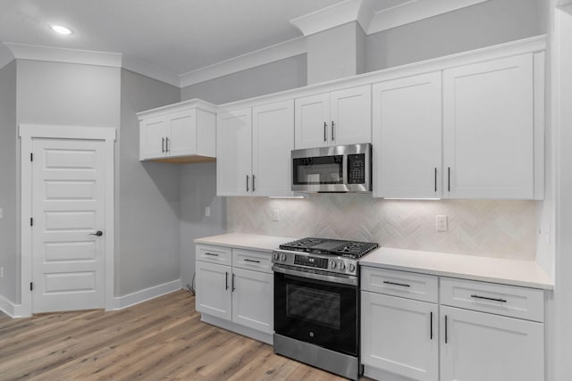 1720 25th St, Niceville, FL 32578 - kitchen featuring stainless steel appliances, baseboards, white cabinets, ornamental molding, and backsplash