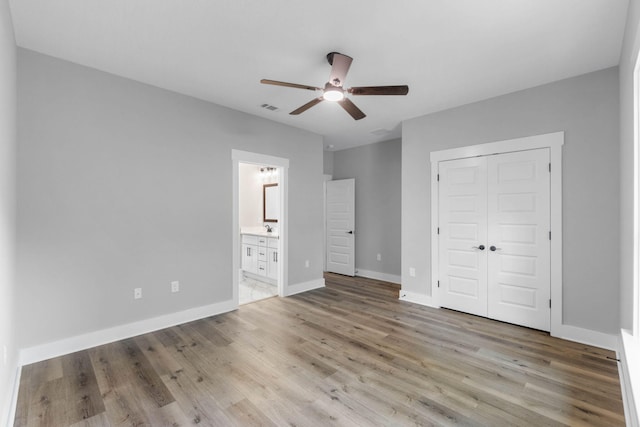 1720 25th St, Niceville, FL 32578 - unfurnished bedroom featuring light wood finished floors, a closet, baseboards, ensuite bathroom, and ceiling fan