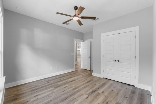 1720 25th St, Niceville, FL 32578 - unfurnished bedroom with wood finished floors, a closet, baseboards, and a ceiling fan