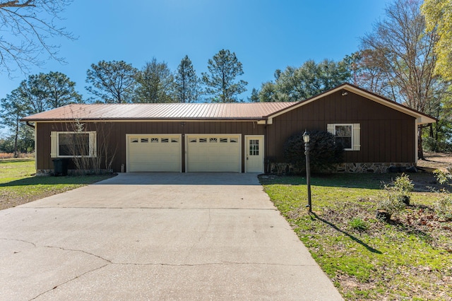 single story home featuring a garage, driveway, metal roof, board and batten siding, and a front yard