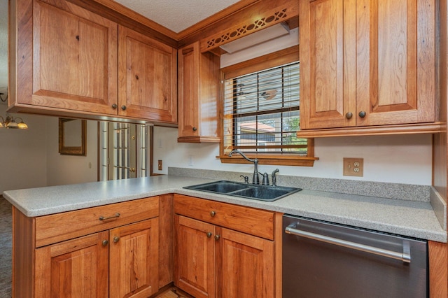 kitchen featuring brown cabinets, a peninsula, light countertops, stainless steel dishwasher, and a sink