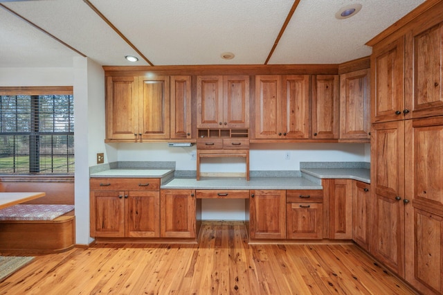 kitchen with light countertops, light wood-style floors, recessed lighting, and brown cabinets