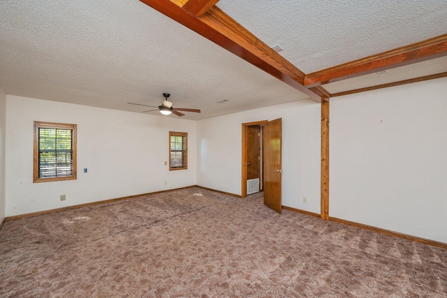 spare room with a textured ceiling, carpet floors, visible vents, baseboards, and beam ceiling