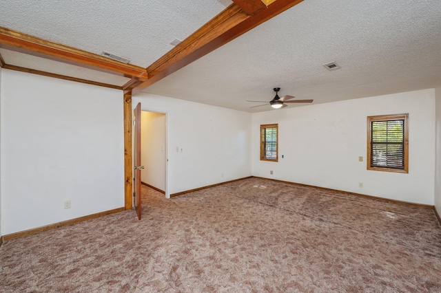 carpeted spare room featuring visible vents, a textured ceiling, and baseboards