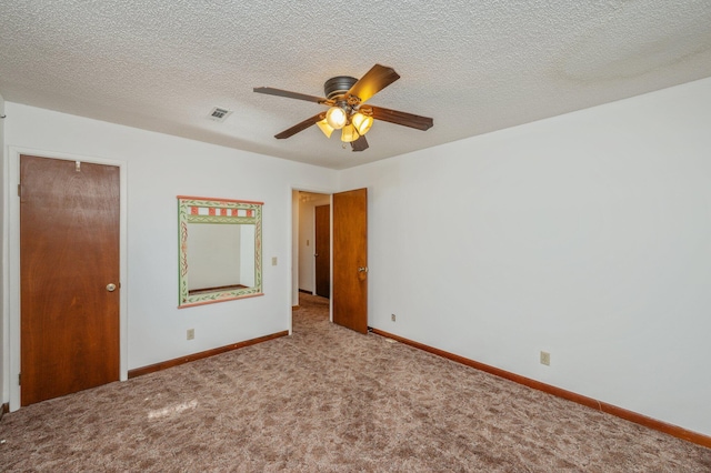 unfurnished bedroom featuring baseboards, visible vents, a textured ceiling, and light colored carpet