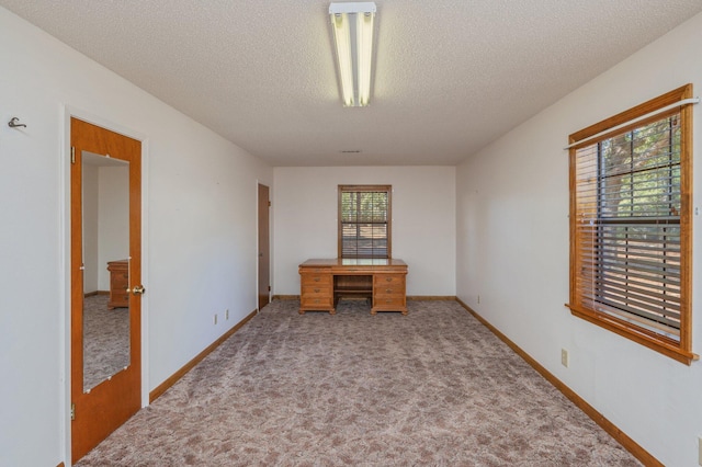 interior space with a textured ceiling and baseboards