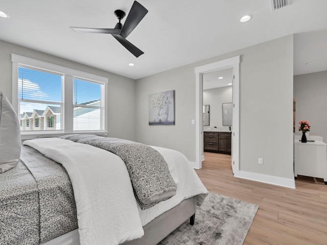 bedroom featuring ceiling fan, light hardwood / wood-style floors, and ensuite bath