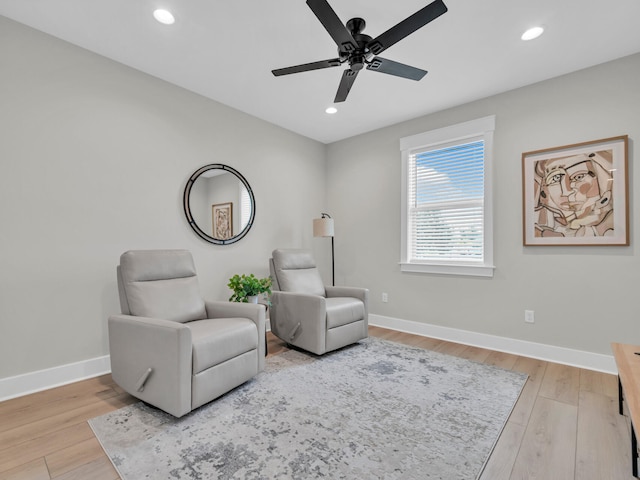 living area with ceiling fan and light hardwood / wood-style flooring