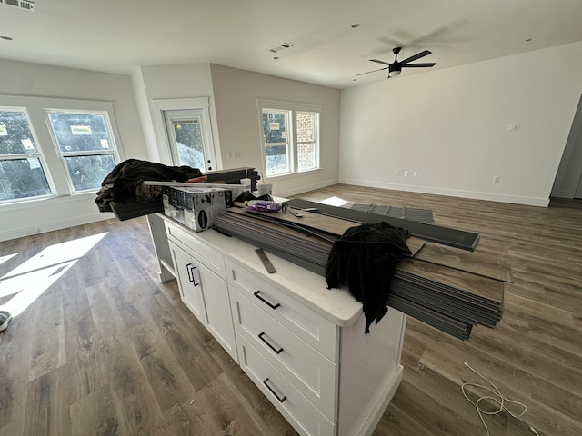 interior space with open floor plan, white cabinets, plenty of natural light, and dark wood-type flooring