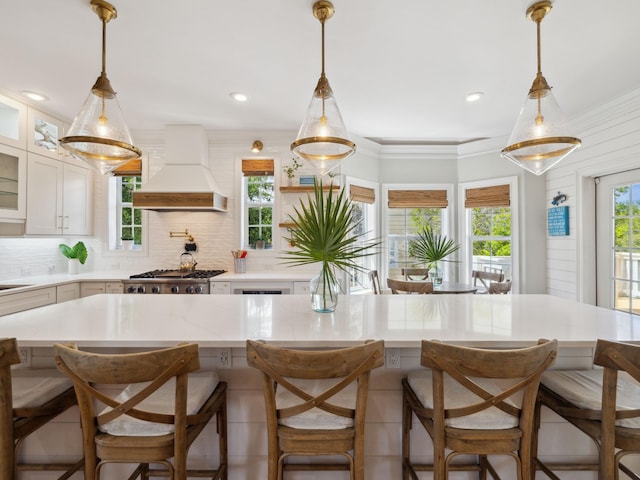 24 High Tide Way, Inlet Beach, FL 32461 - kitchen featuring custom exhaust hood, glass insert cabinets, backsplash, white cabinets, and stainless steel gas stovetop