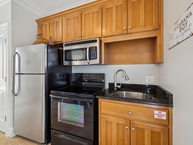 24 High Tide Way, Inlet Beach, FL 32461 - kitchen featuring stainless steel appliances, a sink, dark stone counters, ornamental molding, and brown cabinetry