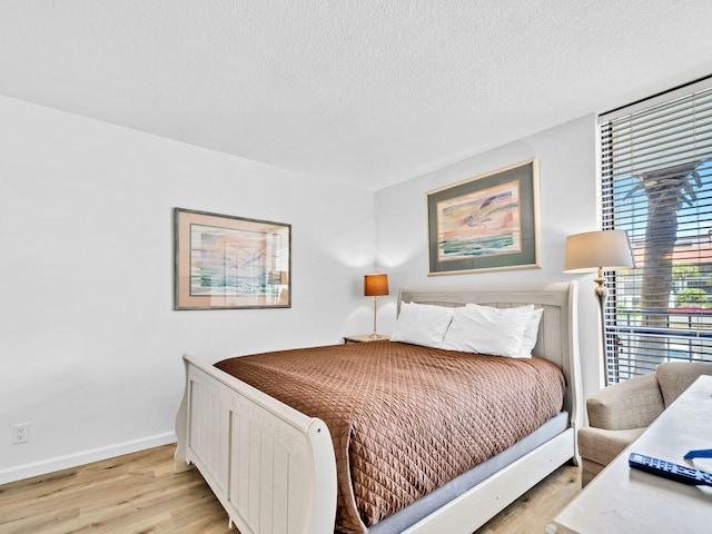 11757 Front Beach Rd Unit W106, Panama City Beach, FL 32407 - bedroom featuring light wood-type flooring, baseboards, and a textured ceiling