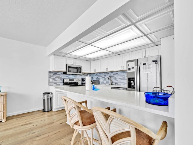 11757 Front Beach Rd Unit W106, Panama City Beach, FL 32407 - kitchen featuring stainless steel appliances, decorative backsplash, white cabinets, and light countertops