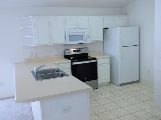 kitchen with white appliances, white cabinets, light tile patterned floors, sink, and kitchen peninsula