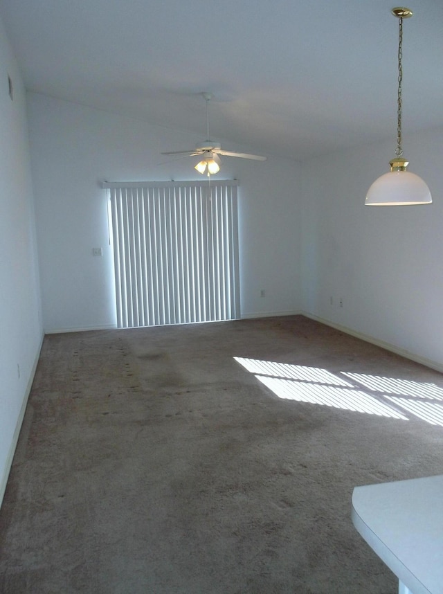 spare room with ceiling fan, dark colored carpet, and lofted ceiling