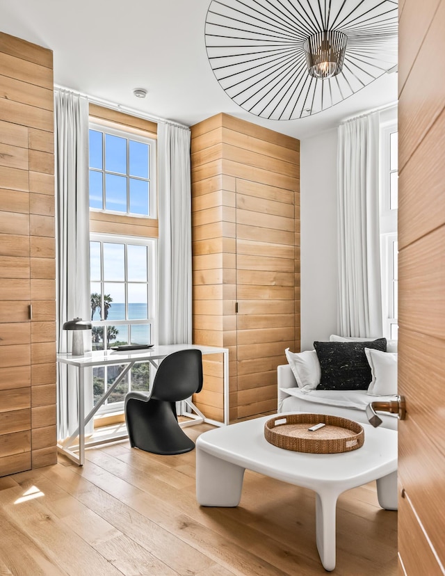 290 Sea Garden St Unit 402, Alys Beach, FL 32461 - living area with a water view, wooden walls, and light wood-type flooring