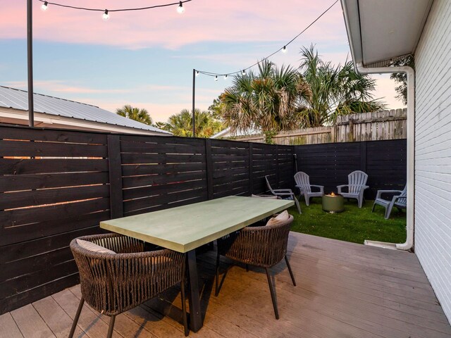 38 Barracuda St, Santa Rosa Beach, FL 32459 - patio terrace at dusk with outdoor dining area, a fenced backyard, and a deck