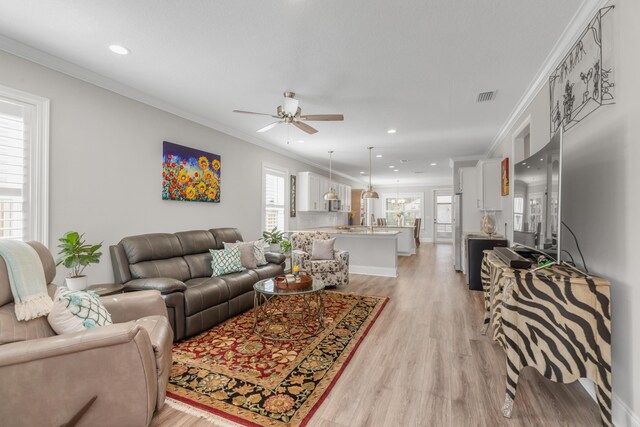 105 Oyster Blvd, Freeport, FL 32439 - living area with visible vents, ornamental molding, and light wood-style flooring