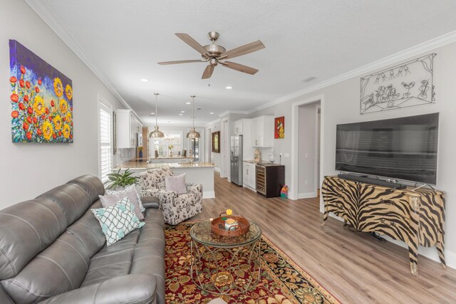 105 Oyster Blvd, Freeport, FL 32439 - living room featuring light wood finished floors, a ceiling fan, and crown molding