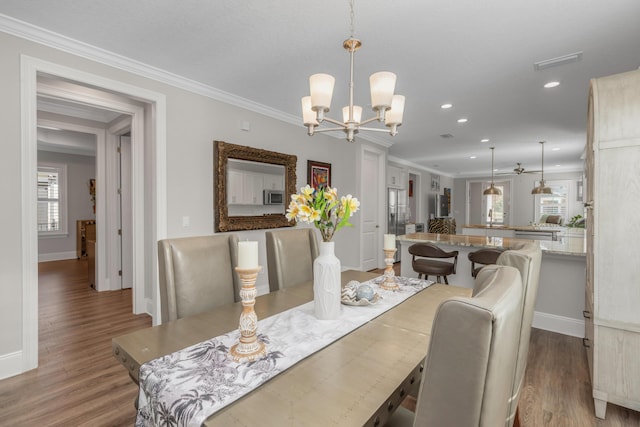 105 Oyster Blvd, Freeport, FL 32439 - dining space with light wood finished floors, visible vents, a chandelier, and crown molding