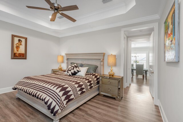 105 Oyster Blvd, Freeport, FL 32439 - bedroom with baseboards, wood finished floors, a raised ceiling, and crown molding