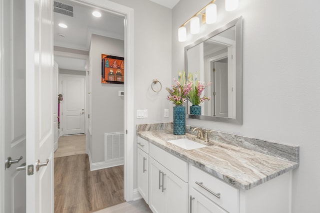 105 Oyster Blvd, Freeport, FL 32439 - bathroom with wood finished floors, vanity, visible vents, and baseboards