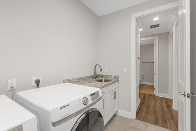 105 Oyster Blvd, Freeport, FL 32439 - clothes washing area with cabinet space, baseboards, visible vents, washer and clothes dryer, and a sink