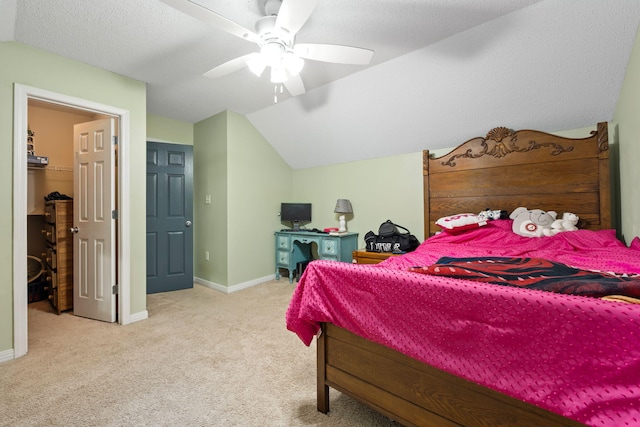 bedroom with light carpet, baseboards, a ceiling fan, lofted ceiling, and a spacious closet