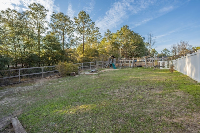 view of yard featuring a playground and a fenced backyard