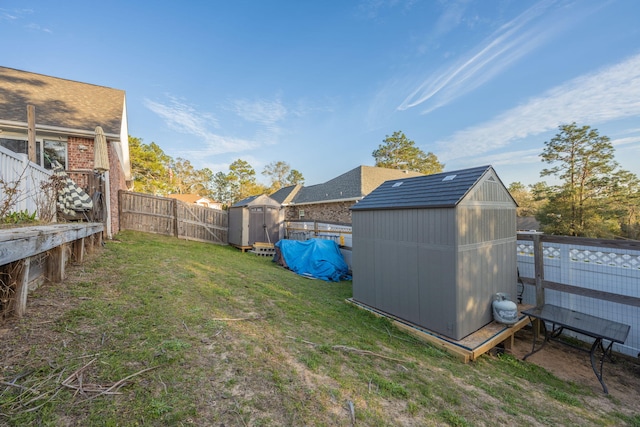 view of yard featuring a fenced backyard, an outdoor structure, and a shed