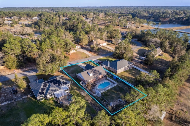 birds eye view of property with a water view and a wooded view