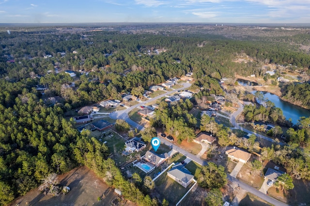 bird's eye view with a water view, a wooded view, and a residential view