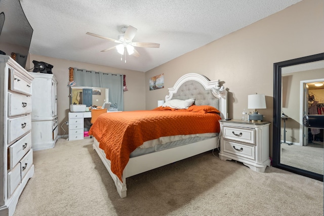 bedroom with a ceiling fan, a textured ceiling, and light colored carpet