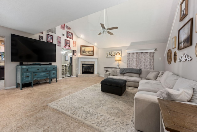 carpeted living area featuring high vaulted ceiling, a fireplace, baseboards, and a ceiling fan