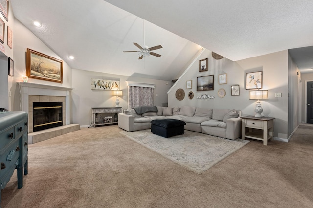 living area with carpet floors, ceiling fan, high vaulted ceiling, a tile fireplace, and baseboards