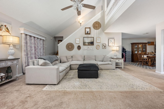 living room featuring a ceiling fan, light colored carpet, high vaulted ceiling, and baseboards