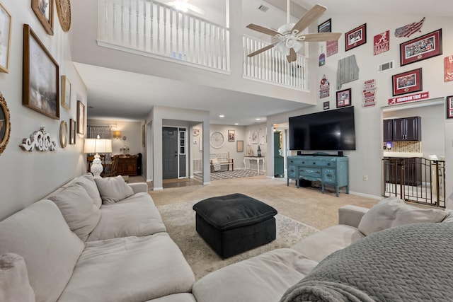 living room featuring light carpet, a ceiling fan, visible vents, and baseboards