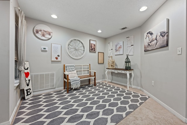 sitting room featuring visible vents, a textured ceiling, and recessed lighting