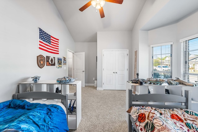 bedroom featuring carpet, a closet, a ceiling fan, high vaulted ceiling, and baseboards