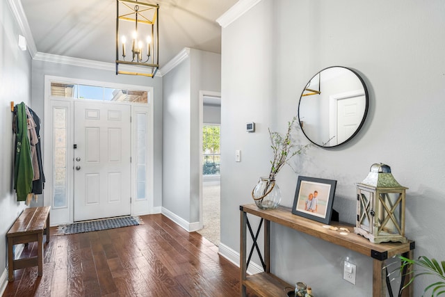 foyer featuring dark wood-style floors, a chandelier, ornamental molding, and baseboards