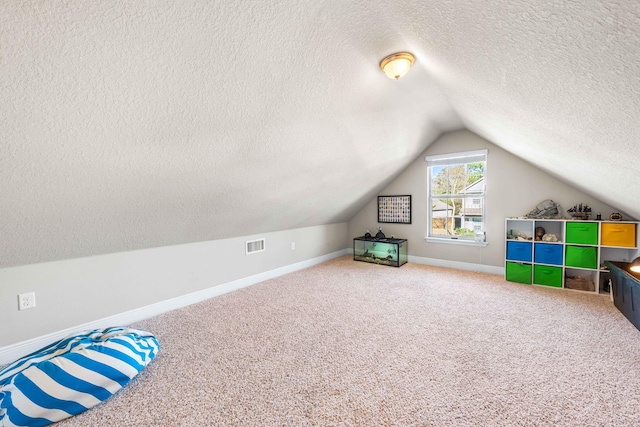 bonus room with carpet floors, visible vents, vaulted ceiling, a textured ceiling, and baseboards