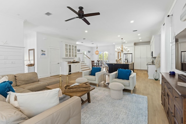 125 Gulfview Cir, Santa Rosa Beach, FL 32459 - living room featuring ceiling fan with notable chandelier, light wood-type flooring, and crown molding