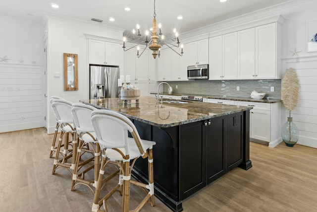 125 Gulfview Cir, Santa Rosa Beach, FL 32459 - kitchen featuring white cabinetry, a center island with sink, stainless steel appliances, sink, and dark stone counters