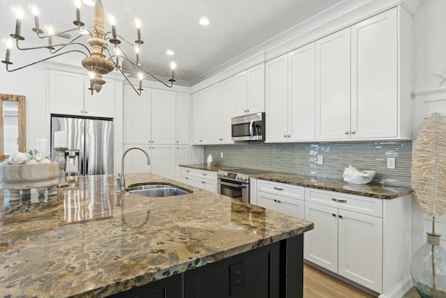 125 Gulfview Cir, Santa Rosa Beach, FL 32459 - kitchen with appliances with stainless steel finishes, dark stone counters, decorative light fixtures, sink, and white cabinetry
