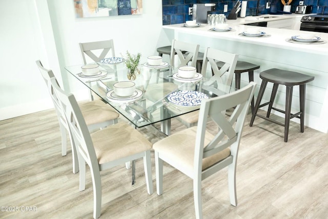 dining area with light hardwood / wood-style flooring and sink