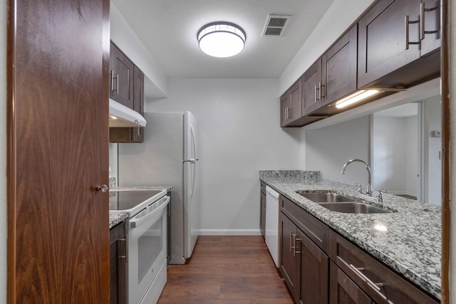 kitchen featuring sink, white appliances, light stone countertops, and dark brown cabinetry