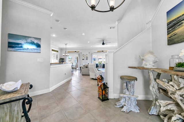 foyer featuring ceiling fan with notable chandelier, visible vents, baseboards, and light tile patterned flooring